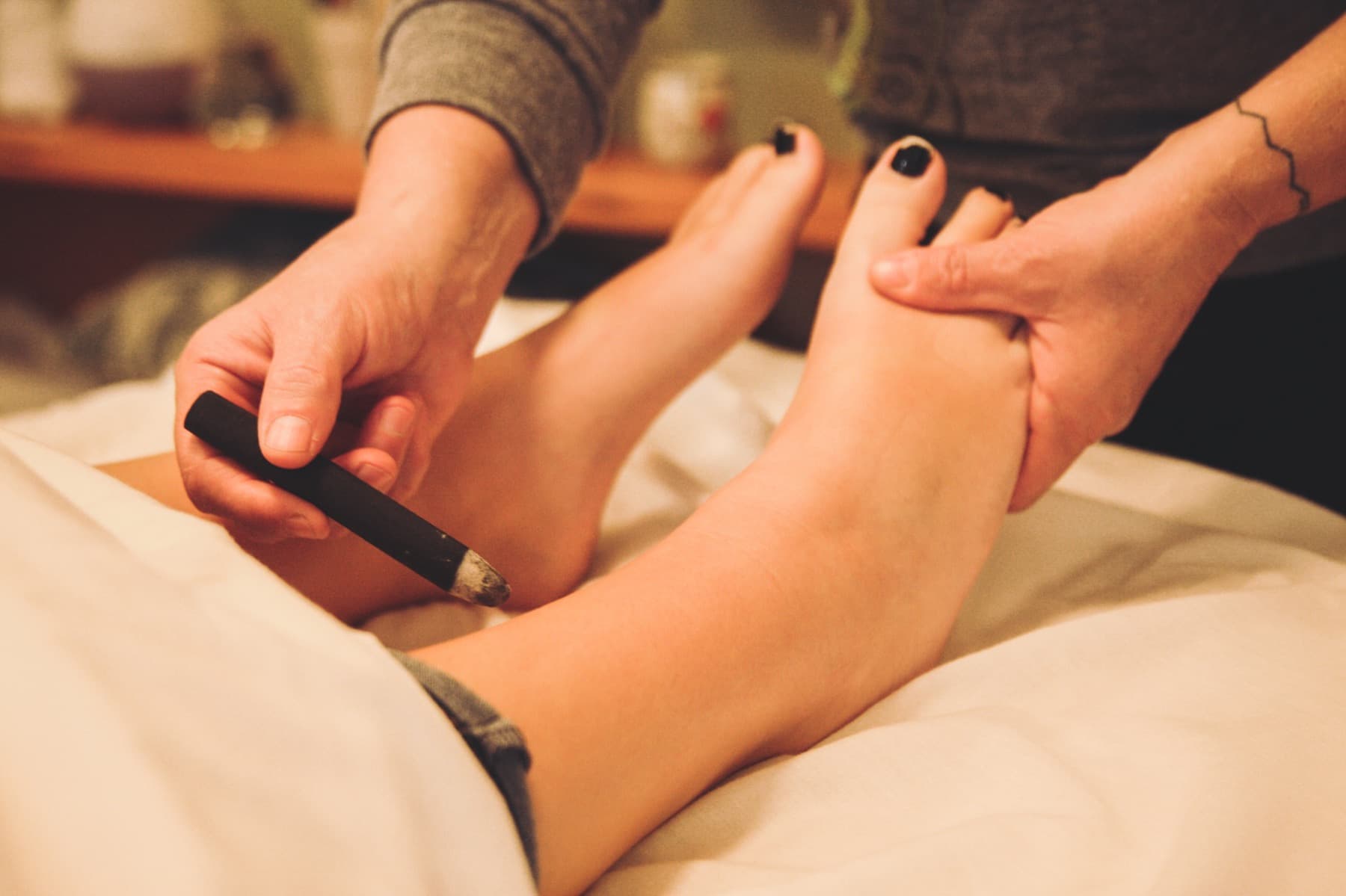 Dr. Rose performing moxibustion on a patient's feet